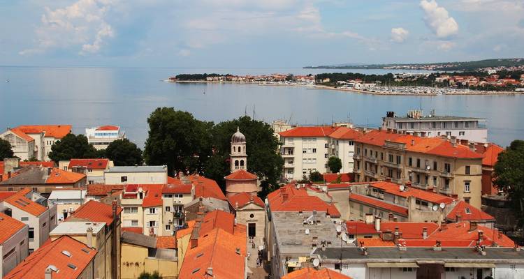 Vue aérienne d'une ville côtière de l'Adriatique avec des toits en terre cuite et une mer bleue calme