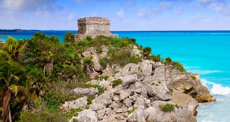 La petite ruine maya perchée en haut de falaise surplombe les eaux turquoise des Caraïbes et la jungle luxuriante à Tulum.