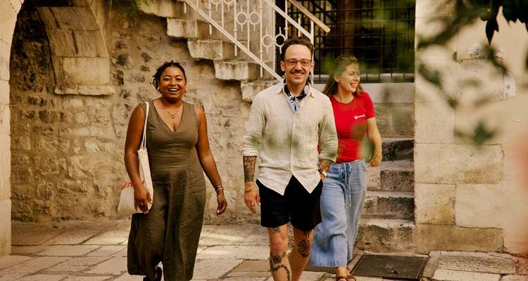 Trois personnes marchant dans un quartier historique.