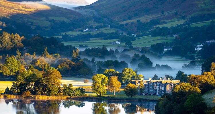Malerische Landschaft mit Nebel und einem großen Gebäude.