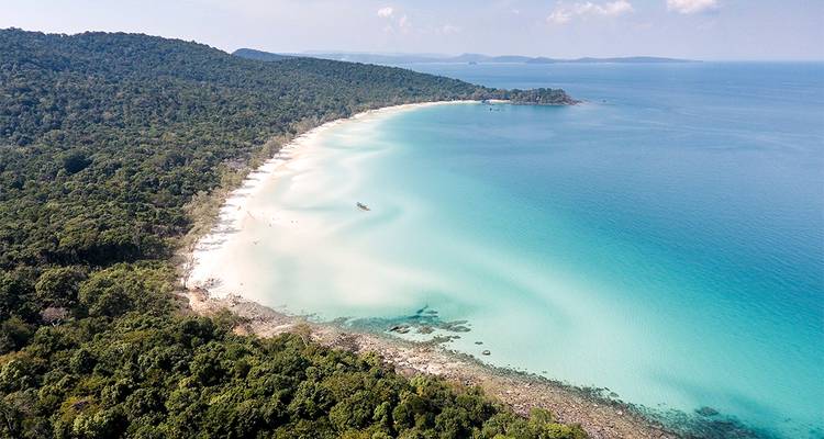 Vue aérienne de la plage de sable blanc immaculé et des eaux turquoise bordées par une jungle dense à Koh Rong.