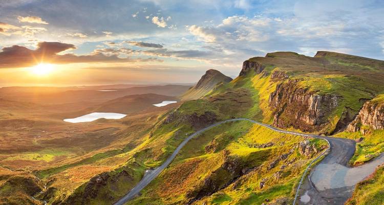 Beautiful landscape with lush greenery and a sunset in the background, likely in Scotland.