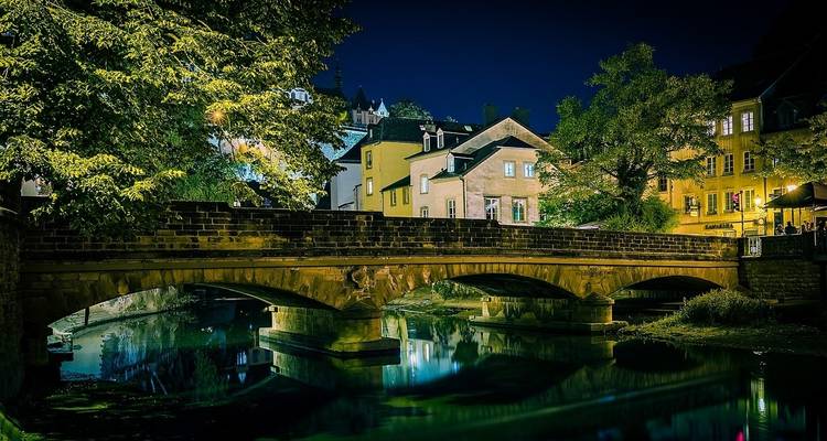 Scenic stone bridge over a calm river at night.