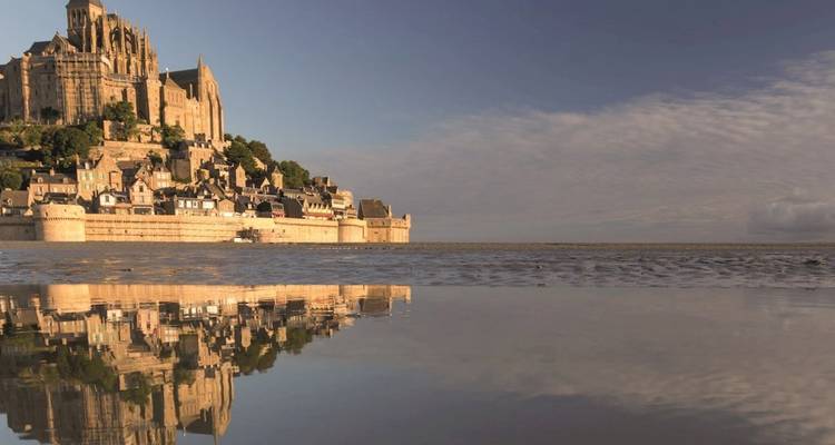 Mont Saint-Michel y su reflejo en la marea baja bajo un suave cielo vespertino