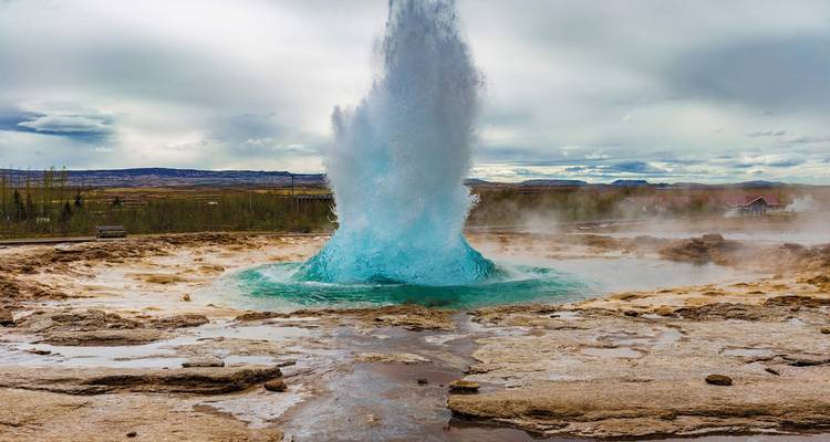 Geysir, der in einer geothermischen Landschaft ausbricht.