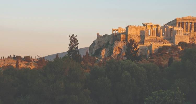 Oude ruïnes op een heuveltop met bomen.