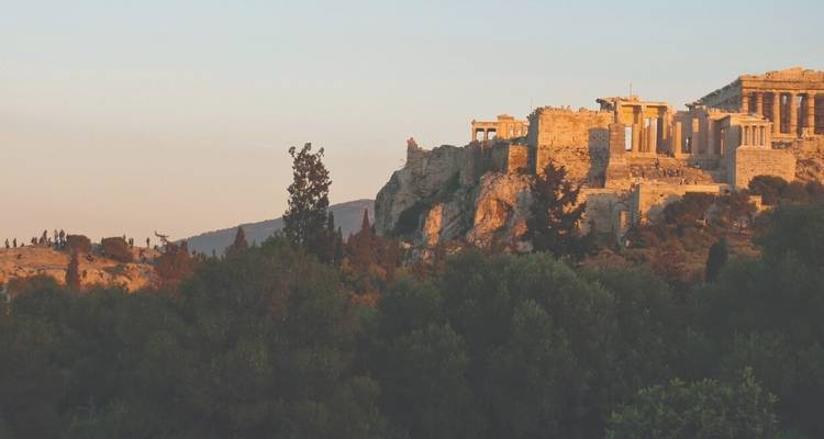 Oude ruïnes op een heuvel omringd door bomen.