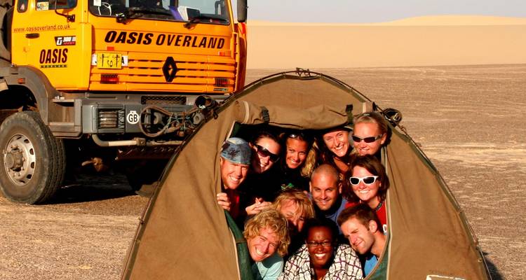 Photo de groupe avec un véhicule de camping et une tente.