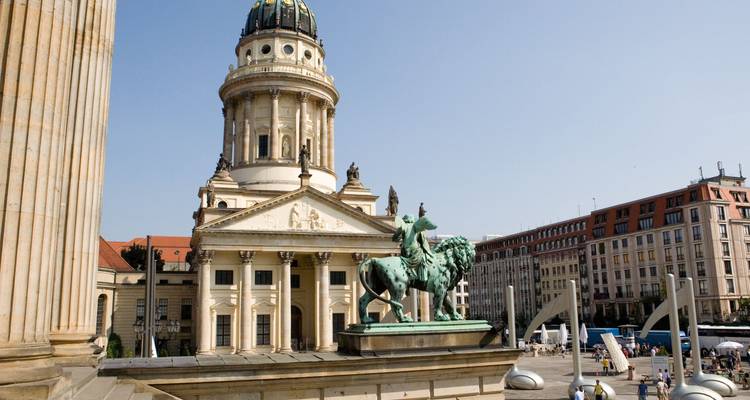 Icónica catedral de Berlín con arquitectura clásica y estatua de caballo.
