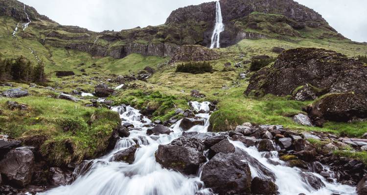 Cascada de múltiples niveles en un valle verde y exuberante.