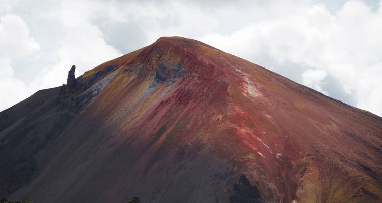 Montagne volcanique colorée avec des couches rouges et noires distinctes.