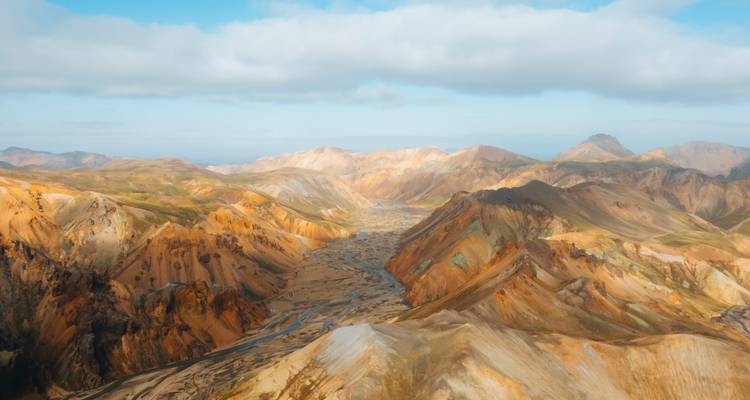 Vue étendue de montagnes et vallées colorées.