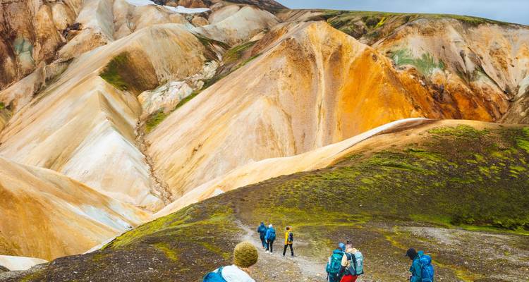 Hikers making their way across multicoloured rhyolite hills and valleys of Landmannalaugar