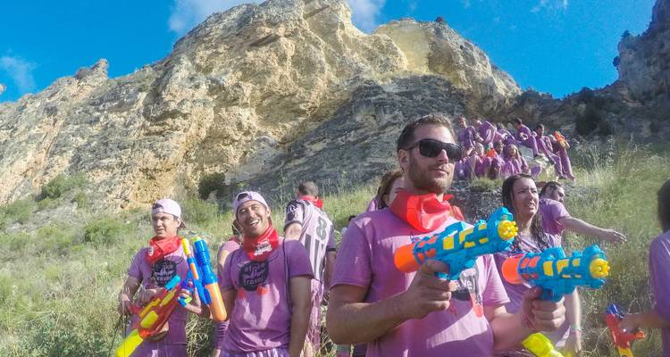 Group of people with water guns at festival.