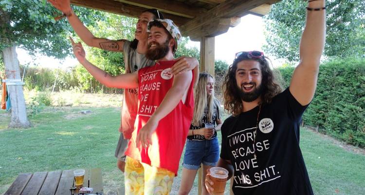 Friends enjoying a backyard party, smiling and holding drinks.