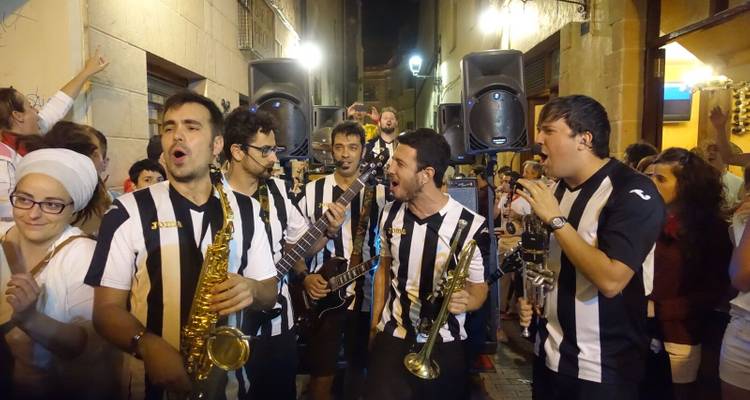 Des musiciens jouant dans la rue, portant des maillots à rayures noires et blanches.