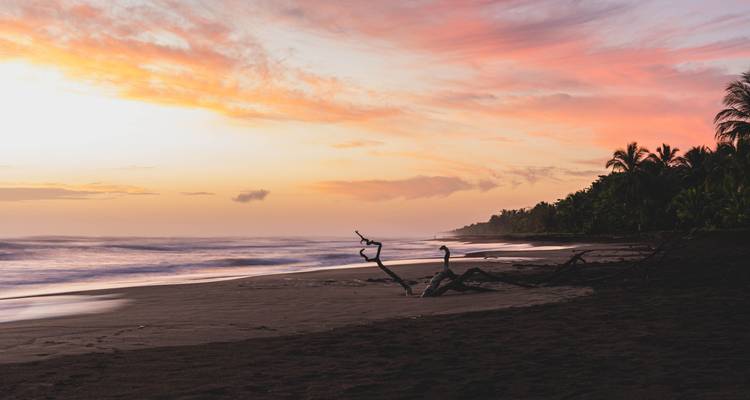 Atardecer sobre una playa tranquila con colores vívidos.