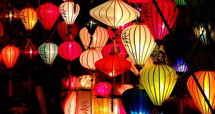 Farolillos de colores iluminados sobre un fondo oscuro.
