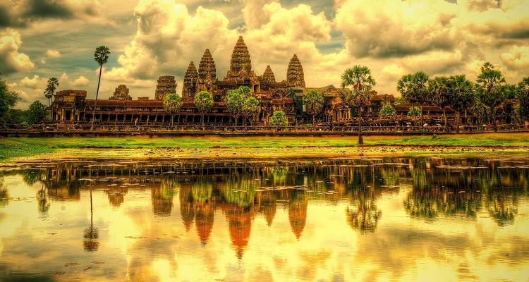 Impresionante vista de Angkor Wat reflejada en el agua con espectaculares nubes.