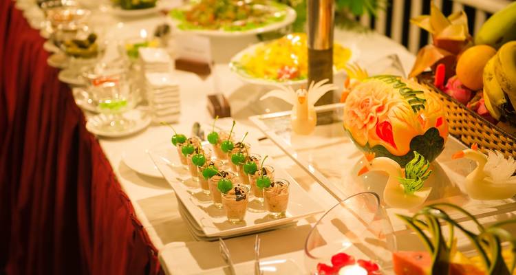 Exquisito montaje de buffet con comida colorida y decoración elegante.