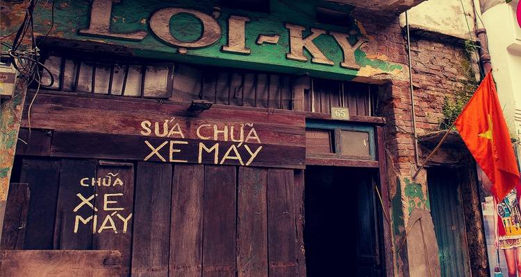 Extérieur d'un magasin traditionnel avec des enseignes vietnamiennes.