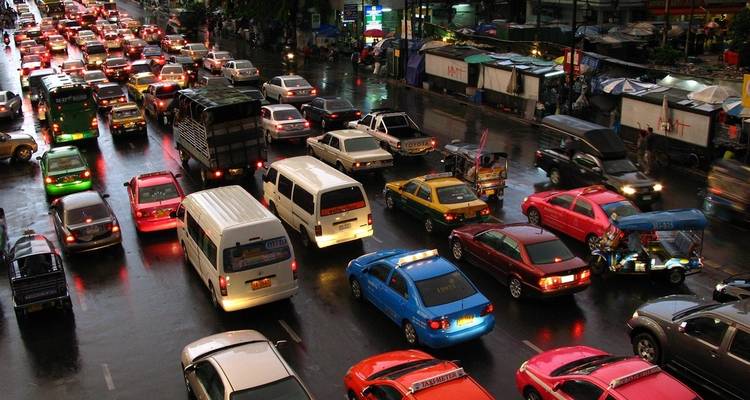 Una concurrida calle de la ciudad llena de vehículos de diversos colores.