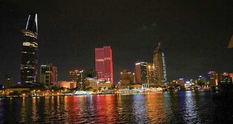 Nachtelijke skyline van een stad met reflecties op het water.