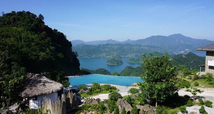 Piscine à débordement avec vue sur les montagnes et la verdure.