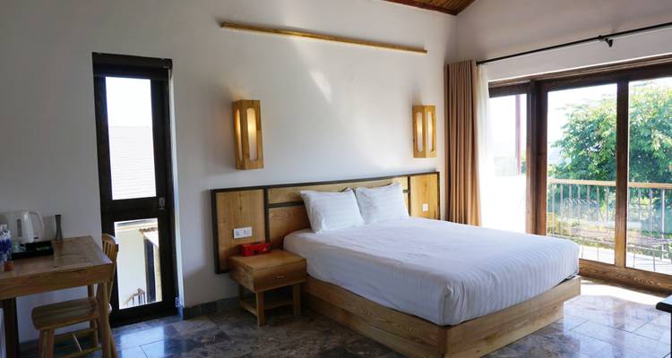 Chambre contemporaine avec décoration moderne et grandes fenêtres donnant sur la verdure.