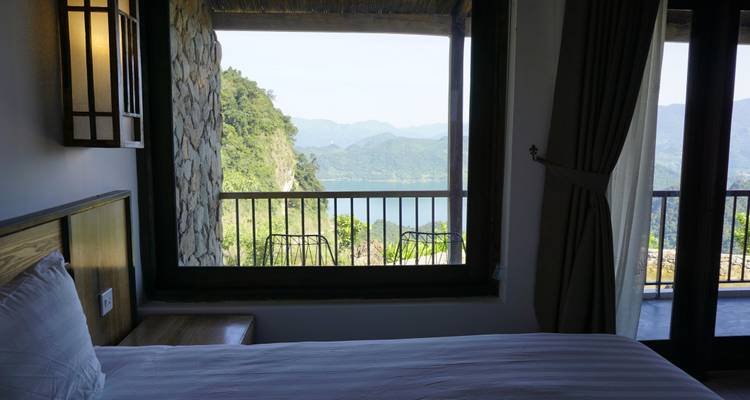Chambre d'hôtel avec vue sur les montagnes par une grande fenêtre.