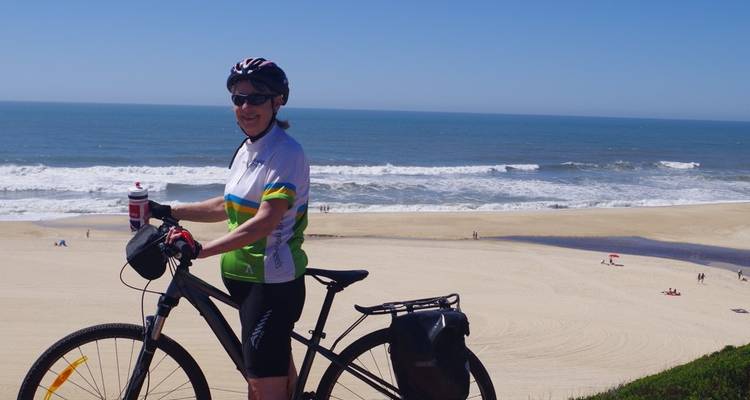 Ciclista en una playa con olas