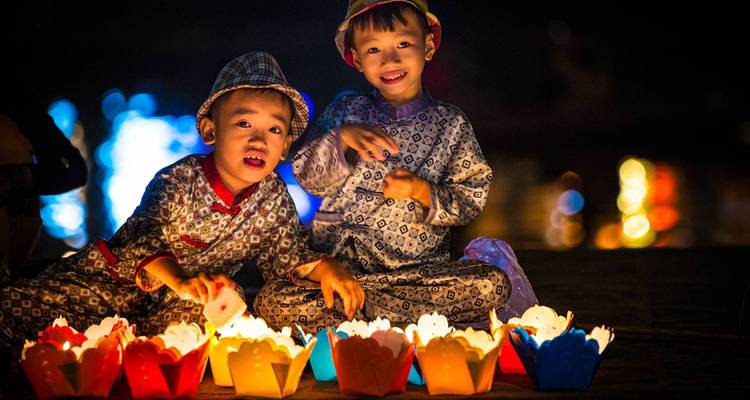 Children engaging with floating lanterns at night