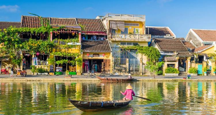 Historic buildings reflecting in a river in Hoi An