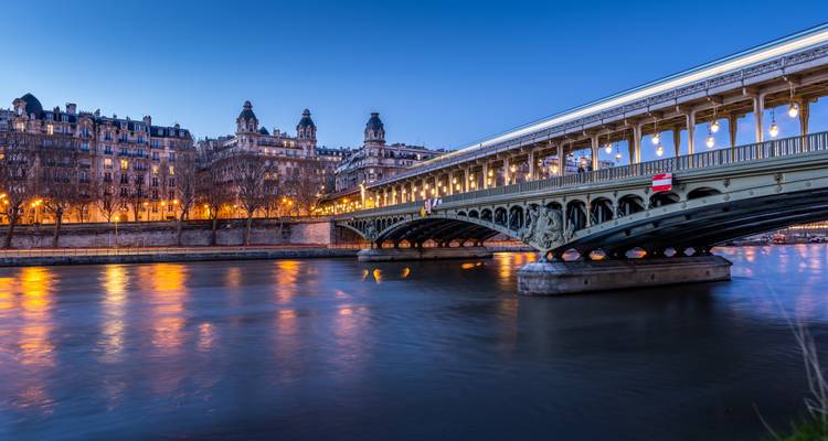 Puente sobre el río Sena con reflejos al atardecer.