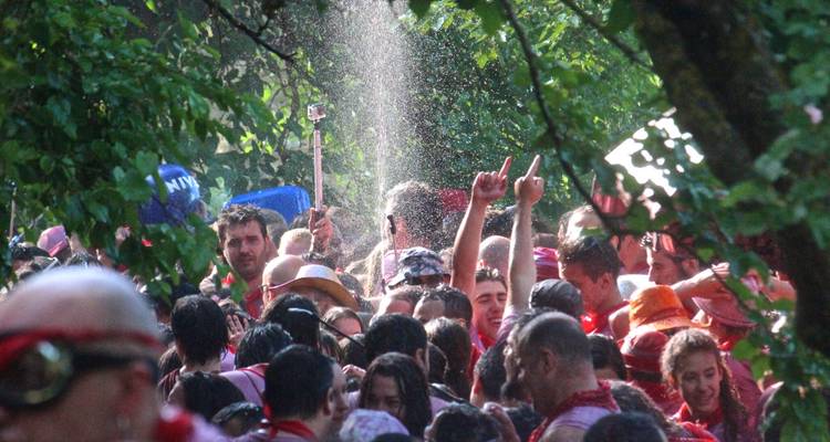 Foule célébrant à l'extérieur avec de l'eau et du vin.