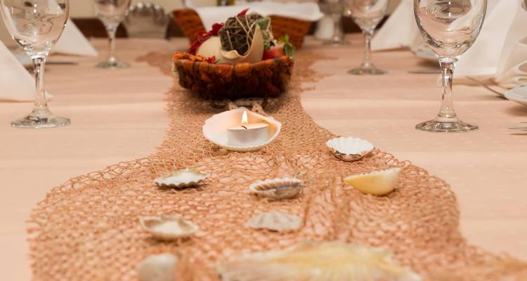 Mesa decorada con conchas y una vela.