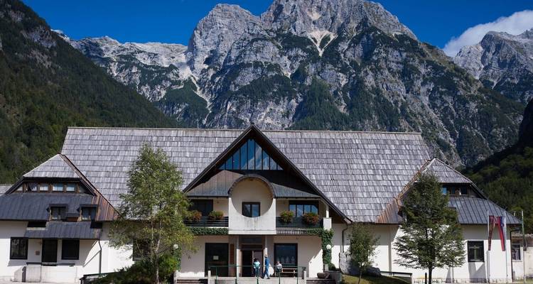 Grand chalet de montagne situé dans une vallée aux sommets imposants.