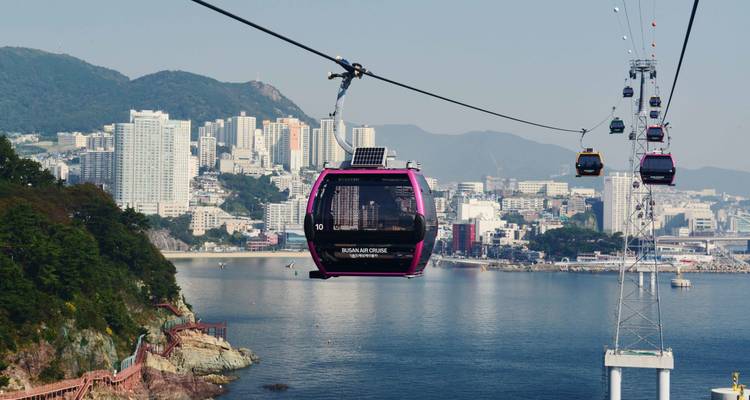 Teleféricos con vista de una ciudad costera.