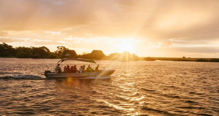 Boat on water during sunset with passengers enjoying the view.