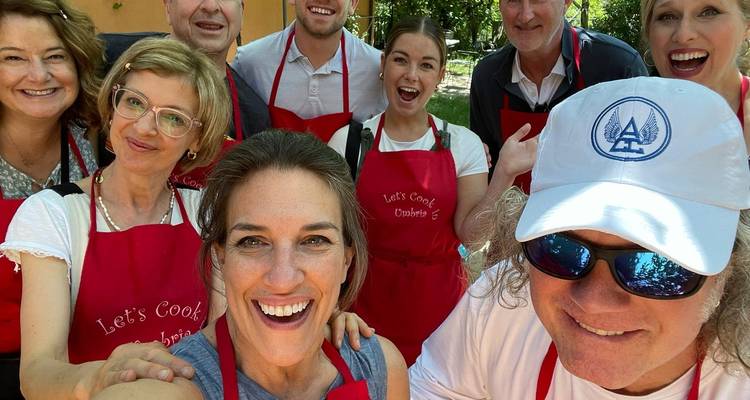 Ein Gruppen-Selfie von Menschen in roten Schürzen bei einer Veranstaltung im Freien.