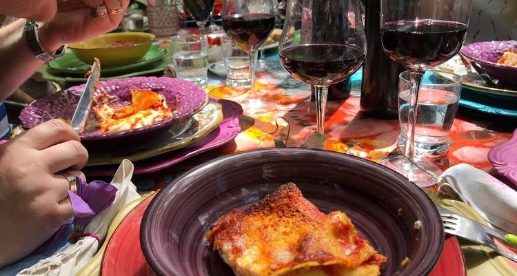 Eine Mahlzeit serviert mit Wein und Nudeln auf einer lebendigen Tischdekoration.