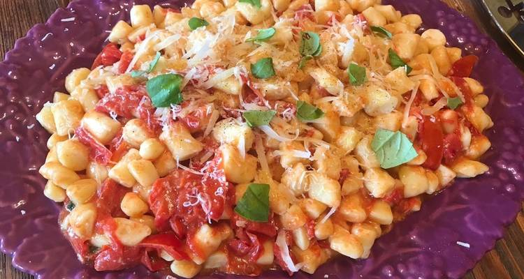 Ein Gericht mit Gnocchi, Kirschtomaten und Basilikum.