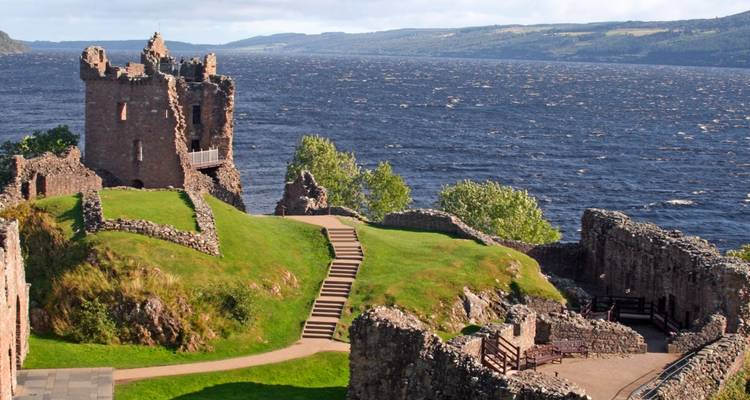 Les ruines d'un château près d'un grand plan d'eau avec une vue pittoresque.