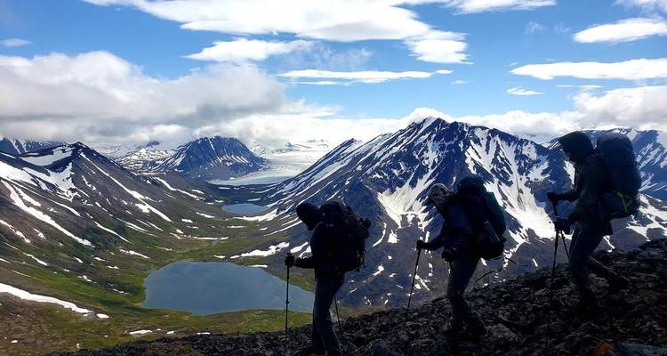 Silhouettes of hikers against a mountainous landscape.