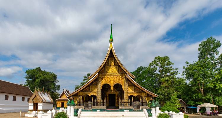 Temple doré orné entouré de verdure.