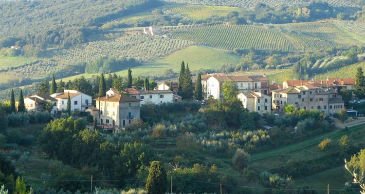 Pequeño asentamiento toscano anidado entre viñedos y olivos durante la hora dorada