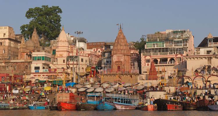 Kleurrijke ghats van Varanasi gezien vanaf de Ganges met veel boten en bruisende activiteit
