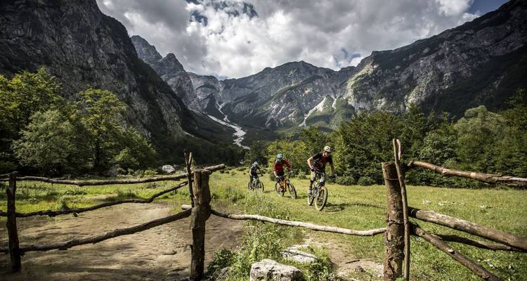 Cyclistes traversant une vallée avec des montagnes en arrière-plan
