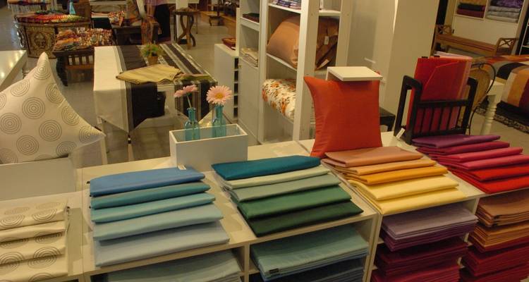 Fabric and cushions on display in a shop.