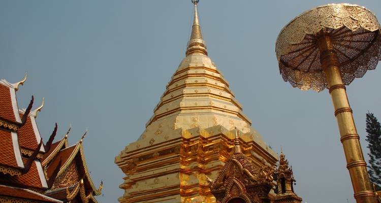 Golden chedi and umbrella structure in a Thai temple.